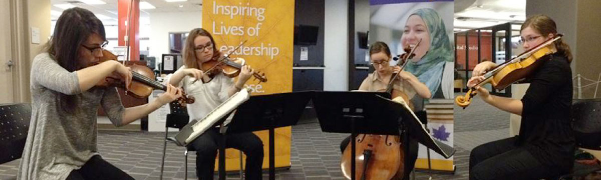 Four musicians playing instruments in the library