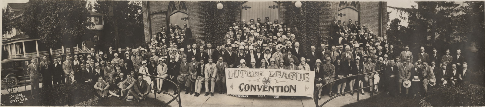 Large group of people in front of church holding a sign for the Luther League Convention.