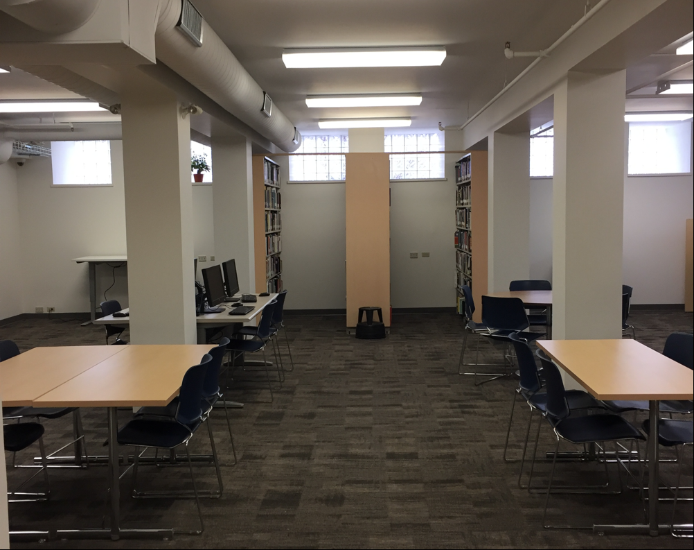 Photo of the part of the library. Middle of the room has tables with chairs around them. Along a wall is 3 book shelfs sticking inwards towards the middle of the room. For more description contact Meredith Fischer, m e f i s c h e r @ w l u dot c a