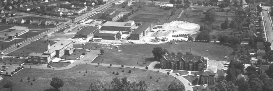 The Waterloo Lutheran University campus from above, circa 1961. Along what is now University Avenue, then named Dearborn Street, is the current Arts Building. Where the Lazaridis Building now resides is St. Michael's Elementary School. Moving eastward into the campus are the current Dining Hall, Theatre Auditorium and MacDonald House, then known as West Hall. Moving east again towards Bricker Avenue are areas under construction and open fields. Where Martin Luther University College stands today are Conrad Hall, the women's residence, and a large brick building known as Willison Hall. On the north side of Bricker Avenue are residential houses