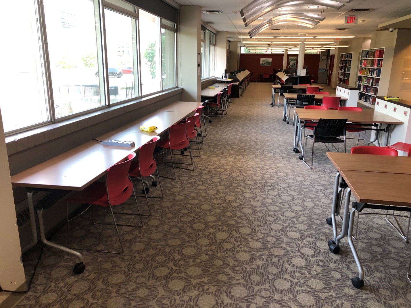 A series of study tables. In the middle of the room are several tables that can seat four people. Along the west side of the building is a row of desks looking out the window to Albert Street.