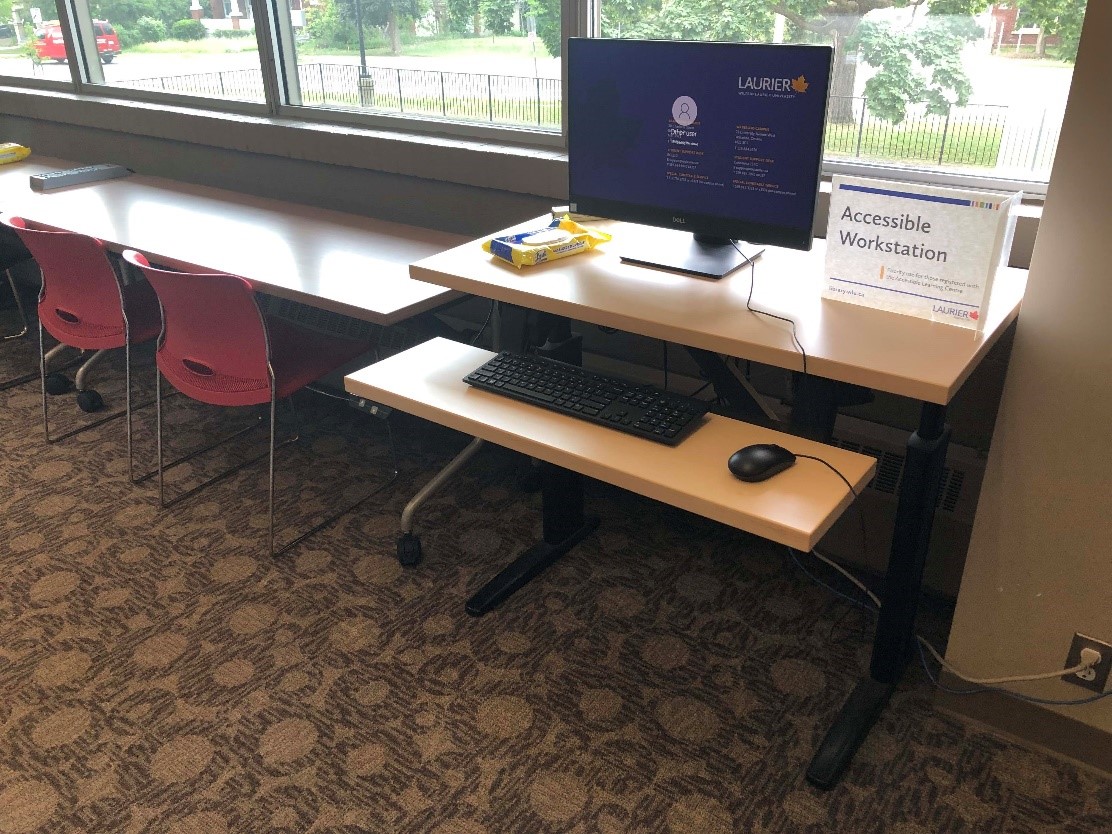 An accessible workstation next to the long desk facing out onto Albert Street. The workstation is on a height adjustable desk
