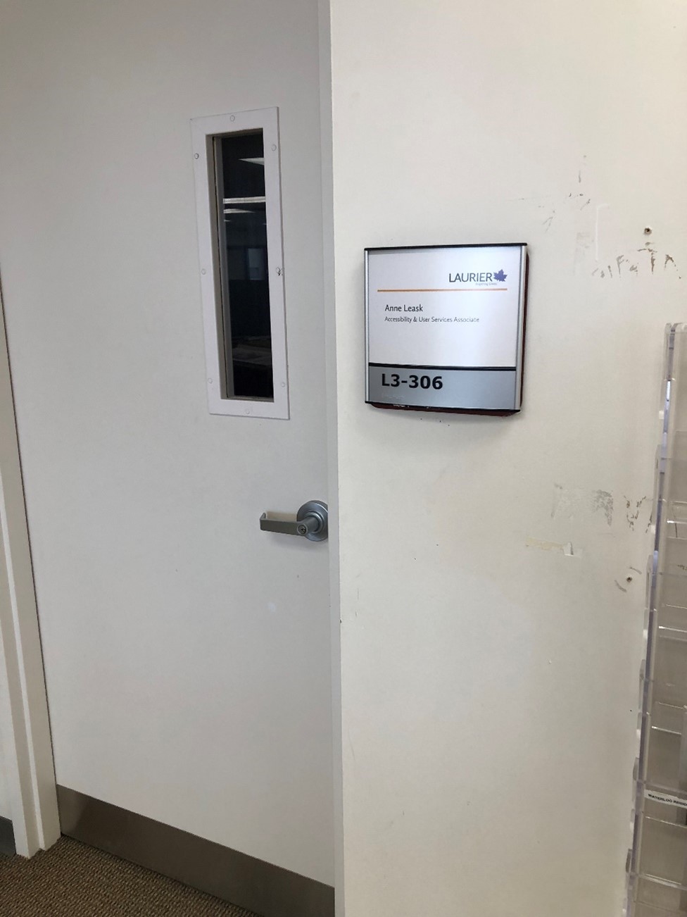 A door with label L3-306. It has braille for the room number. The name is Anne Leask, Accessibility and User Services Associate. There is a narrow window in the door.