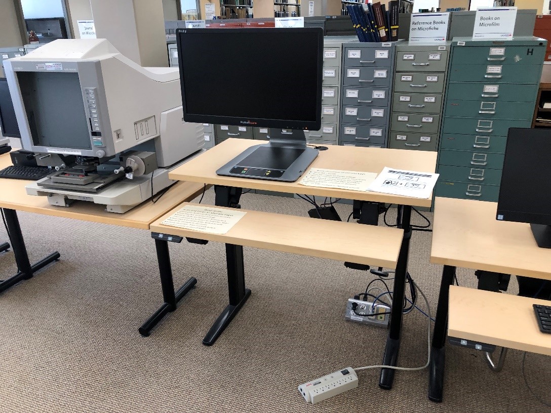 A magnifying display unit. The desk can be elevated or raised. There is a powerbar on the ground. 
