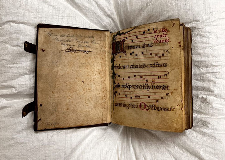 Noted medieval hymnal open to the first folio. First letter of the hymn is illuminated.