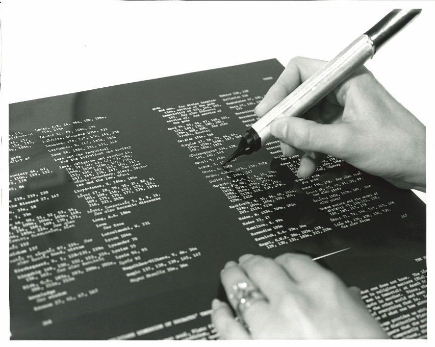WLU Press staff member typesetting a page proof on a light table