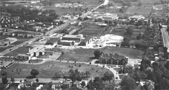 Aerial photograph of the Waterloo Lutheran University in 1962. Willison Hall and the original seminary building can be seen on the lower right-hand side while newer teaching and residence buildings are visible on the left. There are fields in the background.