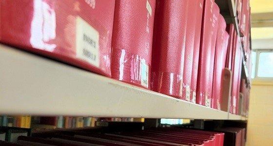 Close up of journals bound in red on a shelf in the Library 