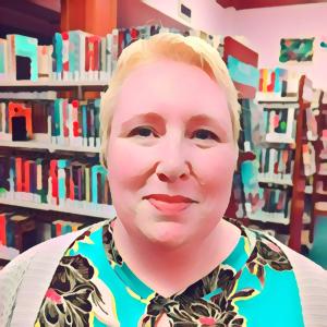 An image of a librarian with short blonde hair standing in front of several bookcases in a library. She smirks.